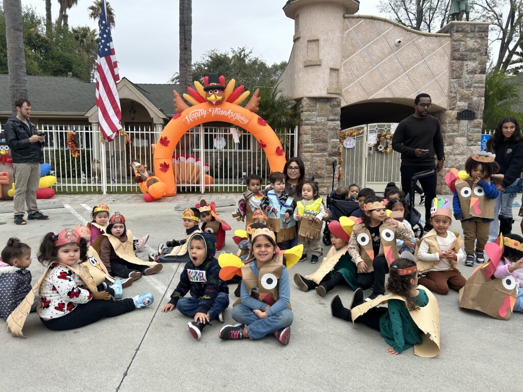 A group of children in colorful costumes smiling and posing together for a photo.